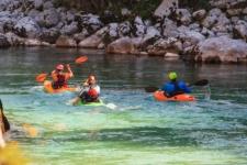 Emerald kayaking Slovenia three kayakers on Soča river.