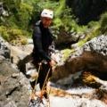 The canyoning guide sets the anchor point for rappelling in Triglav National Park