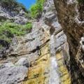 An adventurer descending a majestic waterfall in Triglav National Park, showcasing the park's breathtaking canyoning opportunities