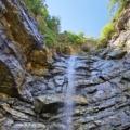 The beauty of Triglav National Park's canyons on full display as a canyoneer rappels down a gushing waterfall