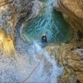 A canyoning enthusiast embracing the diverse experiences of jumping, sliding, and rappelling in the captivating gorges of Triglav National Park